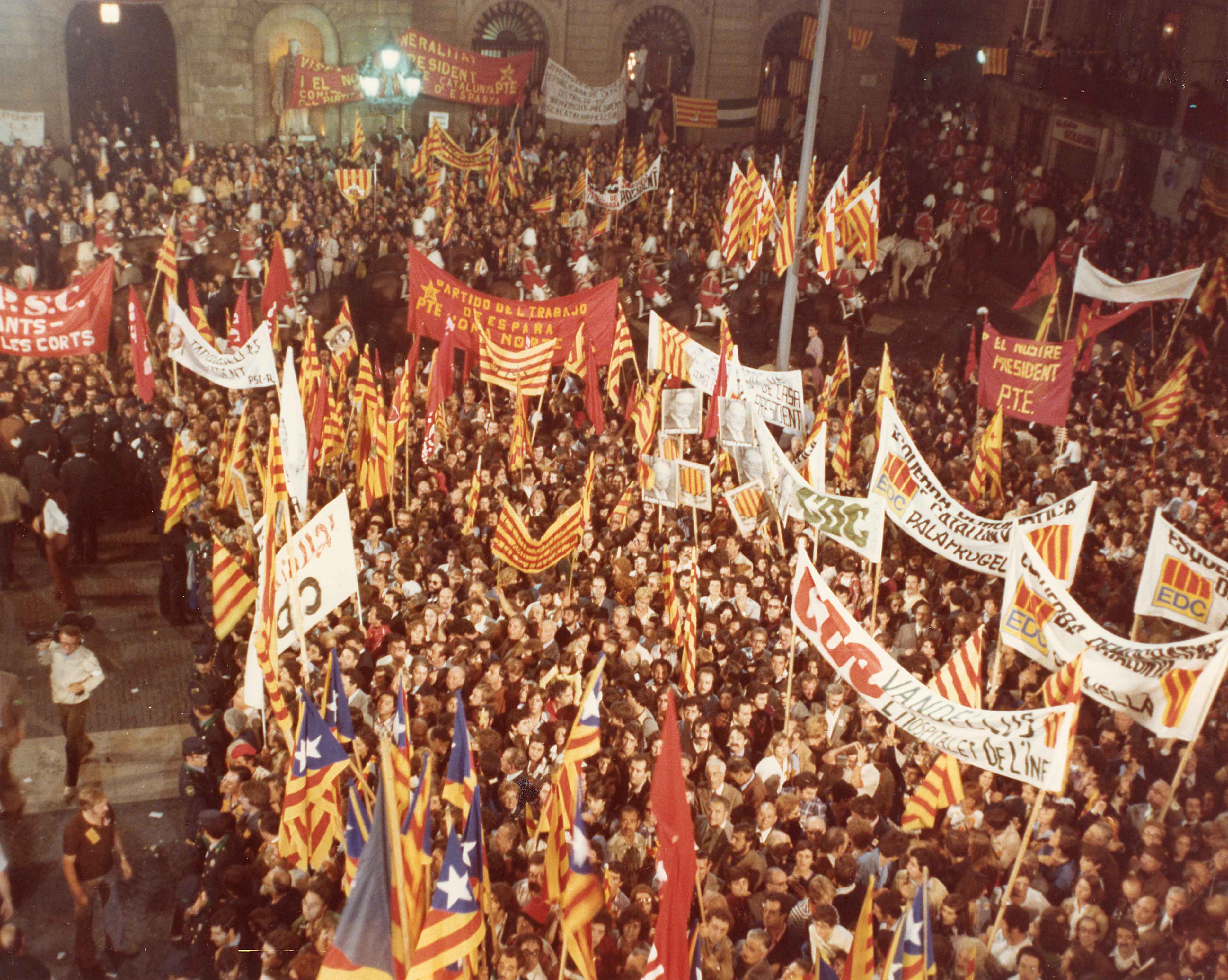 Multitud congregada a la plaça de Sant Jaume amb motiu de l’arribada de Josep Tarradellas al Palau de la Generalitat, 1977. Autoria: Eugenio Castillo Navarro. Fons: Diputació de Barcelona (CAT AGDB R.30942)