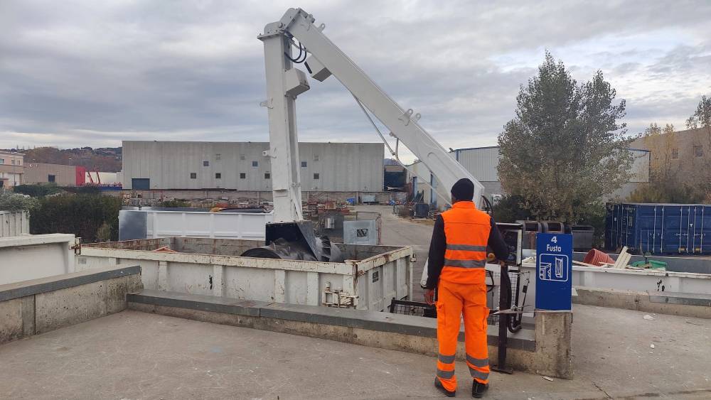 Operari utilitzant un rodet compactador al contenidor de fusta d’una deixalleria.