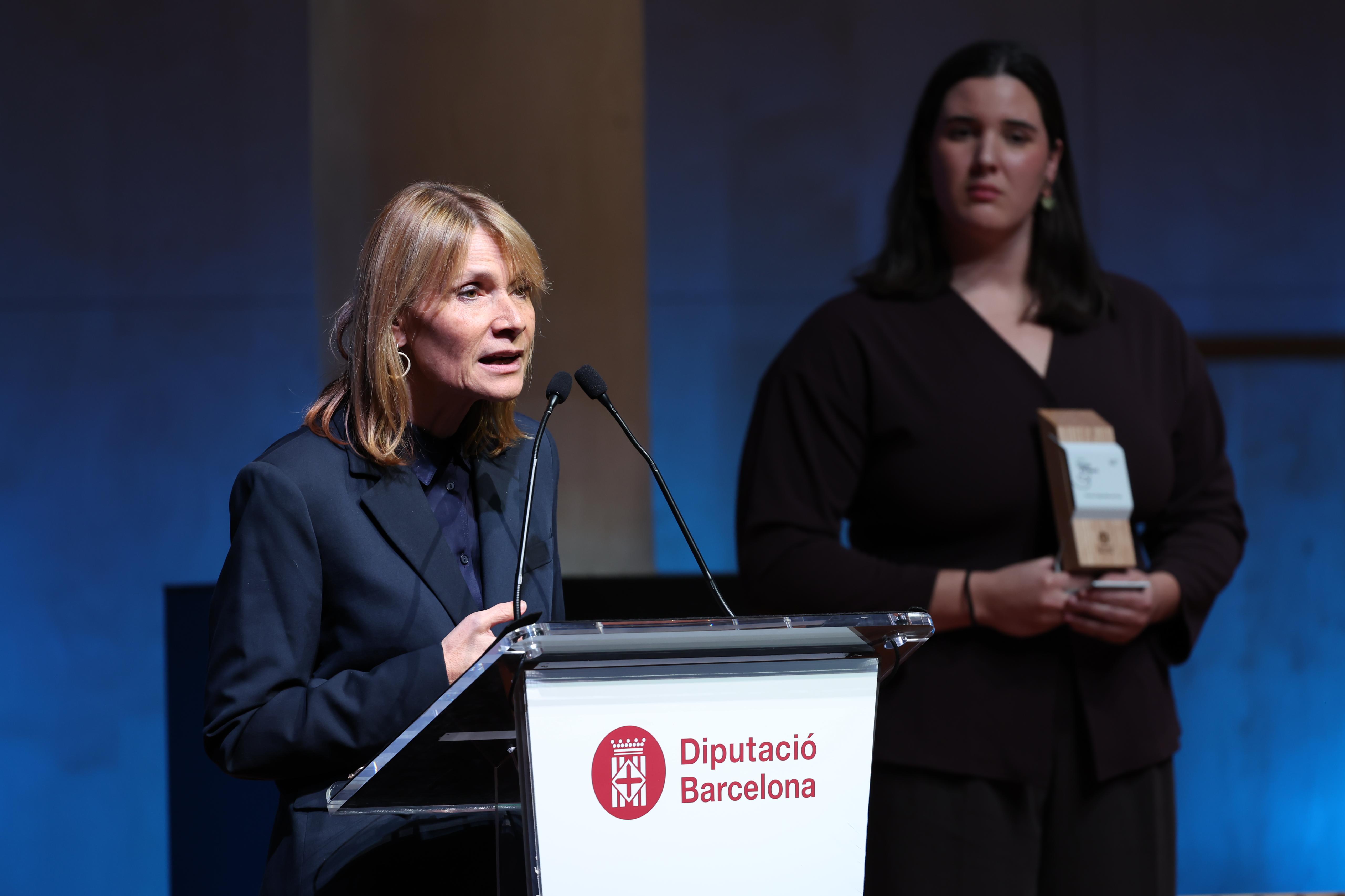 La presidenta Lluïsa Moret durant la seva intervenció a la gala de la I edició del Premis Dones d'Esport. Al fons la waterpolista Paula Leitón. Foto: Pau Fabregat/Diputació de Barcelona La presidenta Lluïsa Moret durant la seva intervenció a la gala de la I edició del Premis Dones d'Esport. Al fons la waterpolista Paula Leitón. Foto: Pau Fabregat/Diputació de Barcelona